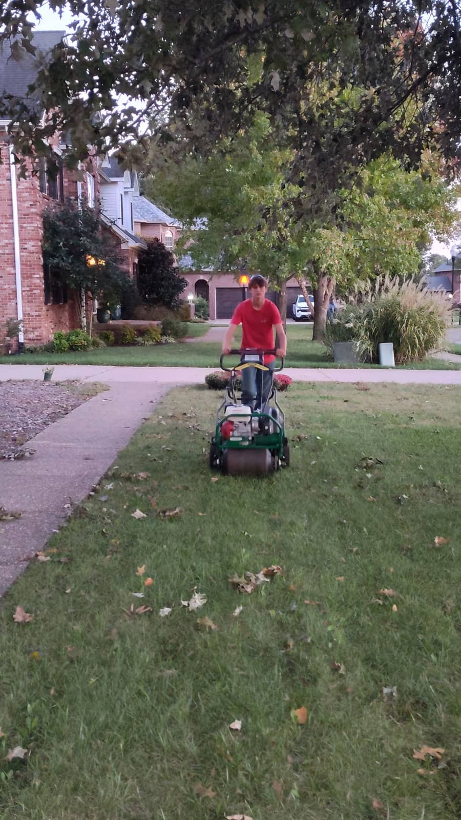 Elite Exteriors team aerating a large neighborhood lawn in Southern Indiana