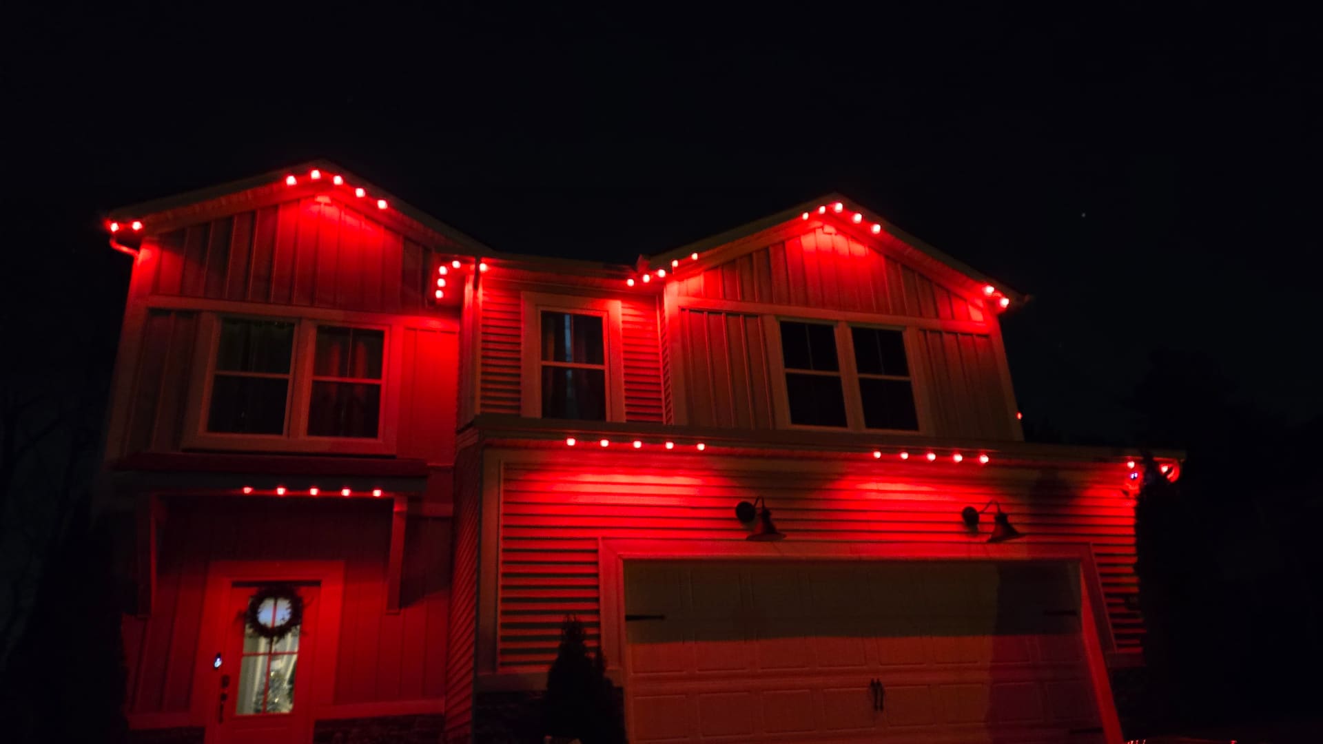 Residential eaves with warm red permanent LED accent lighting installed by Elite Exteriors