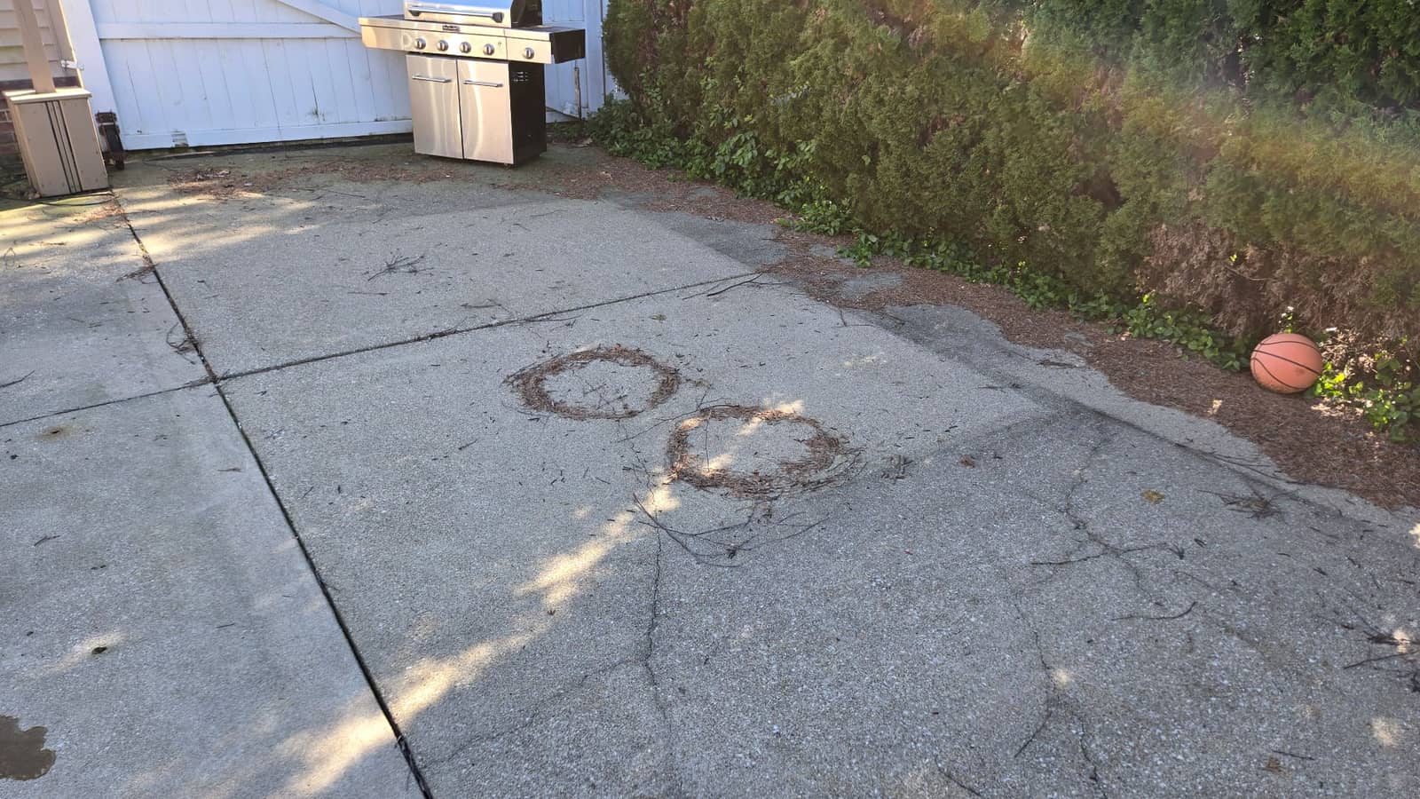 Concrete patio darkened by mildew and grime before pressure washing by Elite Exteriors