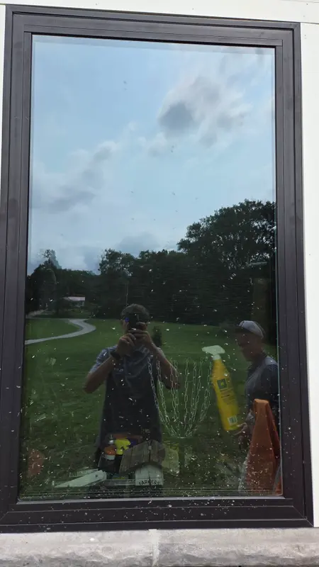 A large dark-framed picture window covered in spots and specks of dirt before cleaning.