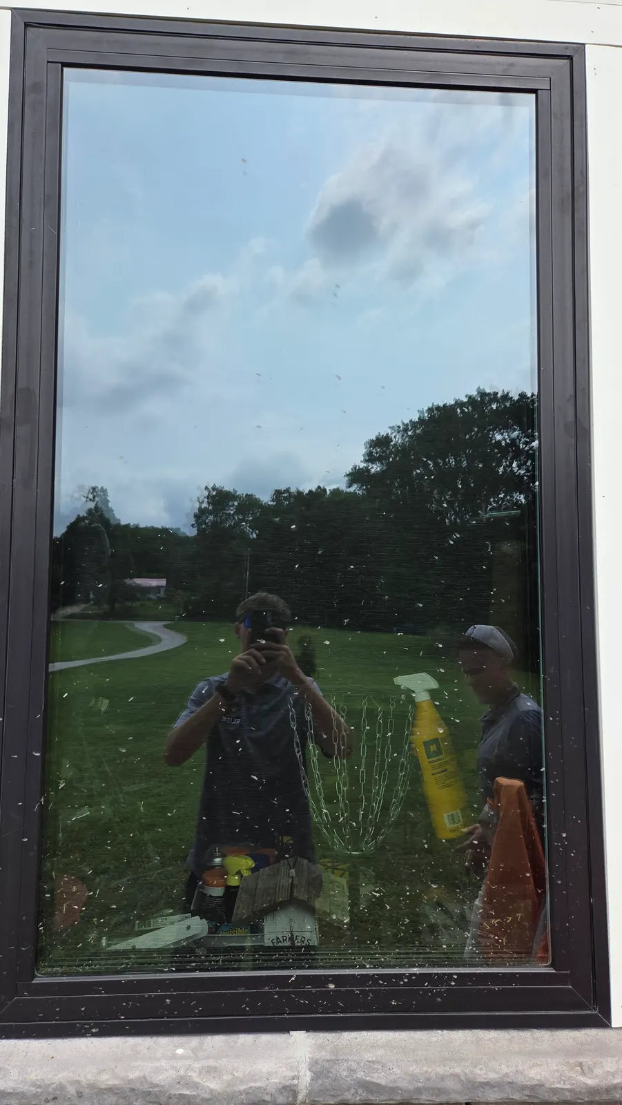 A large dark-framed picture window covered in spots and specks of dirt before cleaning.