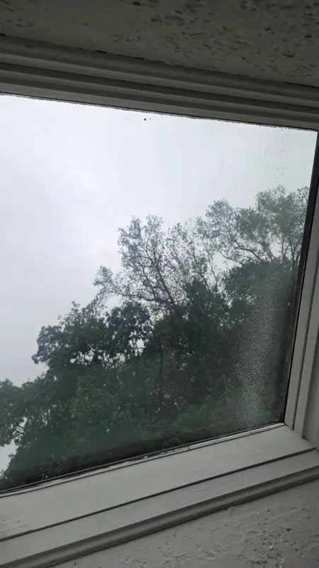 A skylight seen from inside with water spots and a dirty film across the glass.